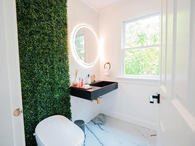 a bathroom with a toilet a sink and a mirror