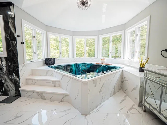 a spacious bathroom with a tub sink and mirror