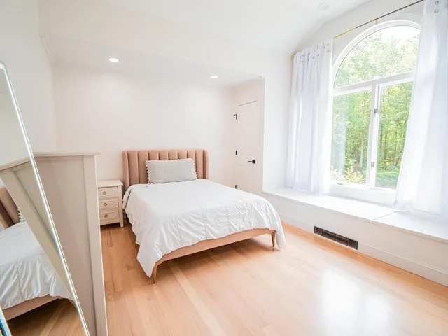 a bedroom with a bed and a large window