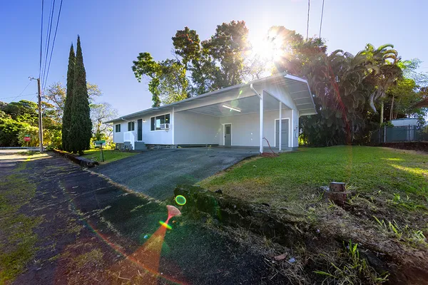 a view of a house with backyard and a tree