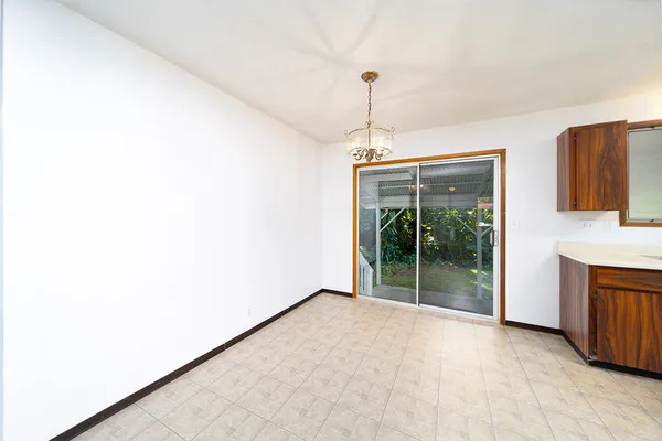 a view of empty room with floor to ceiling window and fireplace