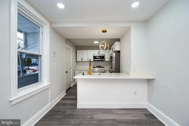 a view of kitchen with cabinets and window