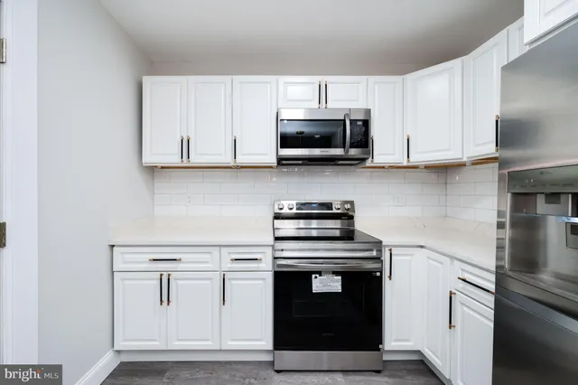 a kitchen with cabinets stainless steel appliances and a sink