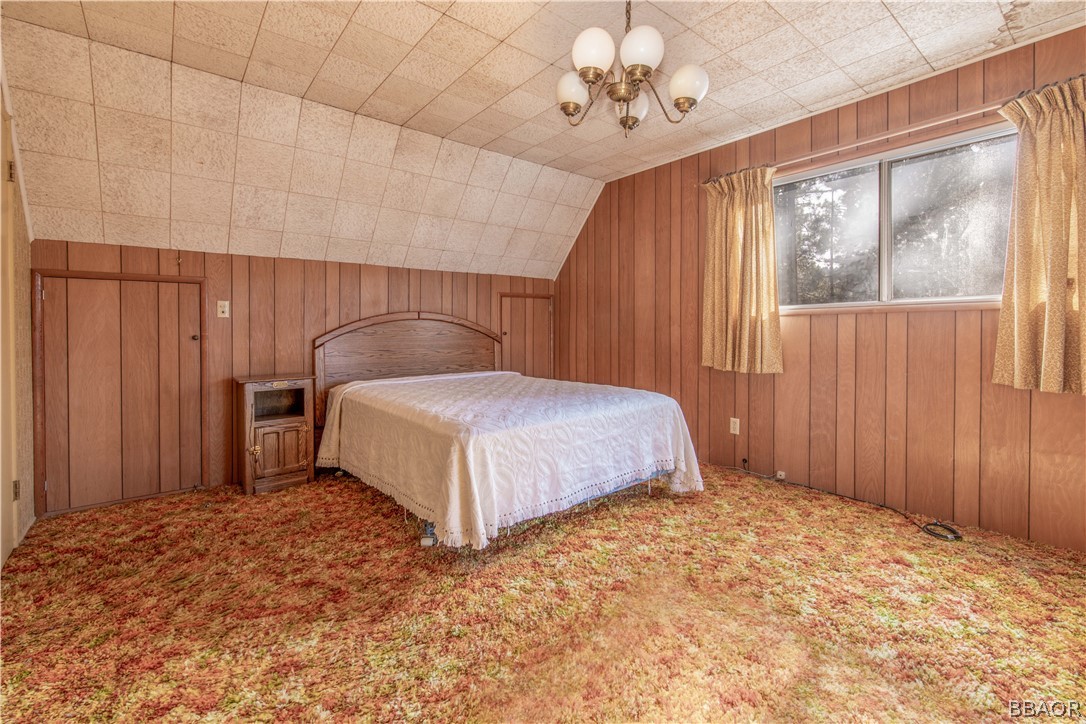 458 Edgemoor Road Big Bear Lake, CA 92315 - Photo 26 of 47 a bedroom with a large bed and a chandelier