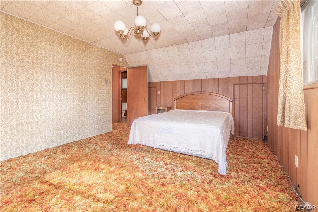 458 Edgemoor Road Big Bear Lake, CA 92315 - Photo 27 of 47 a bedroom with a bed and a chandelier