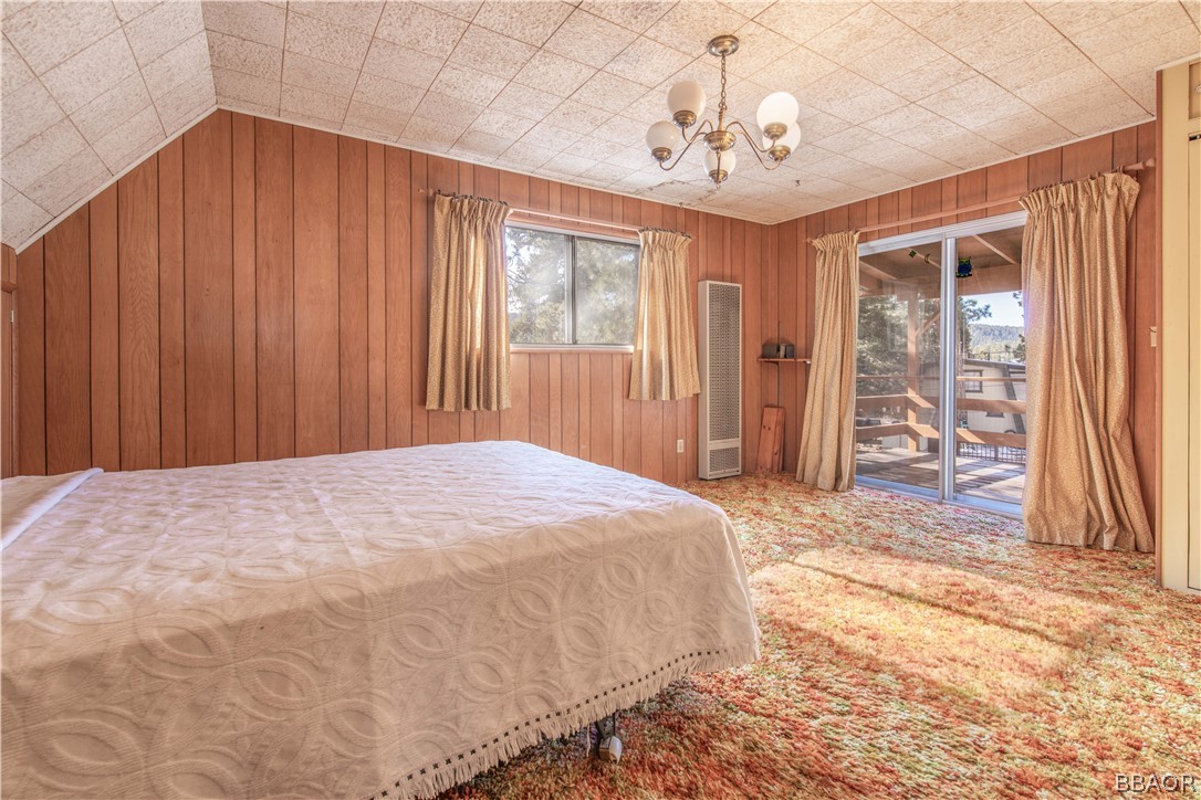 458 Edgemoor Road Big Bear Lake, CA 92315 - Photo 28 of 47 a spacious bedroom with a large bed and chandelier