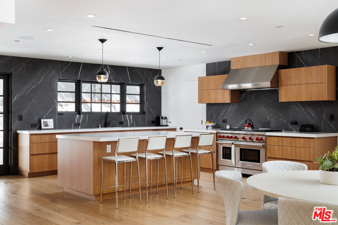 1118 Tower Road Beverly Hills, CA 90210 - Photo 5 of 16 a kitchen with stainless steel appliances a stove a sink and a refrigerator