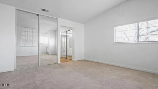 an empty room with windows and closet