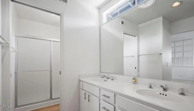a bathroom with a double vanity sink and mirror
