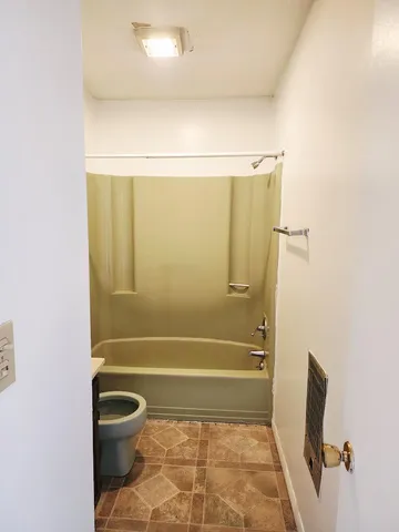 a bathroom with a toilet and shower