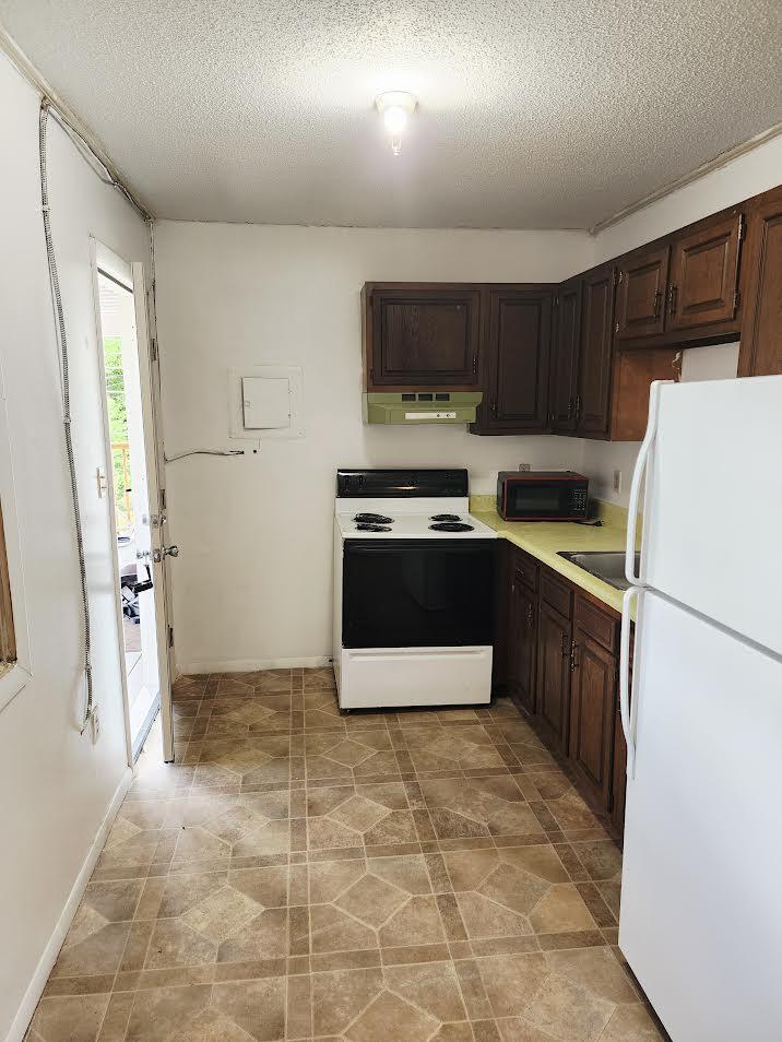 159 Bottom Road, Unit 4 Raven, VA 24639 - Photo 7 of 13 a kitchen with stainless steel appliances granite countertop a refrigerator stove a sink dishwasher and wooden cabinets