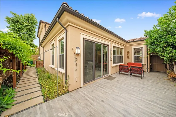 a backyard of a house with wooden floor and outdoor seating