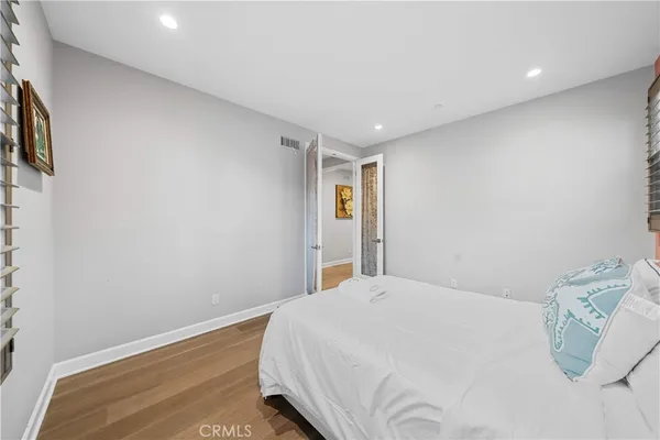 a bedroom with a bed and painting on the wall