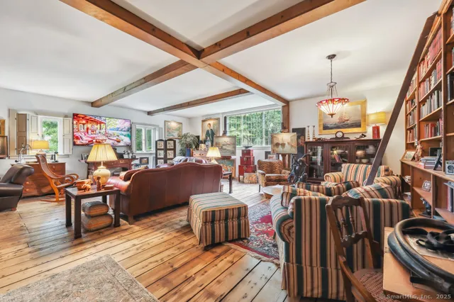a living room with lots of furniture a chandelier and a large window