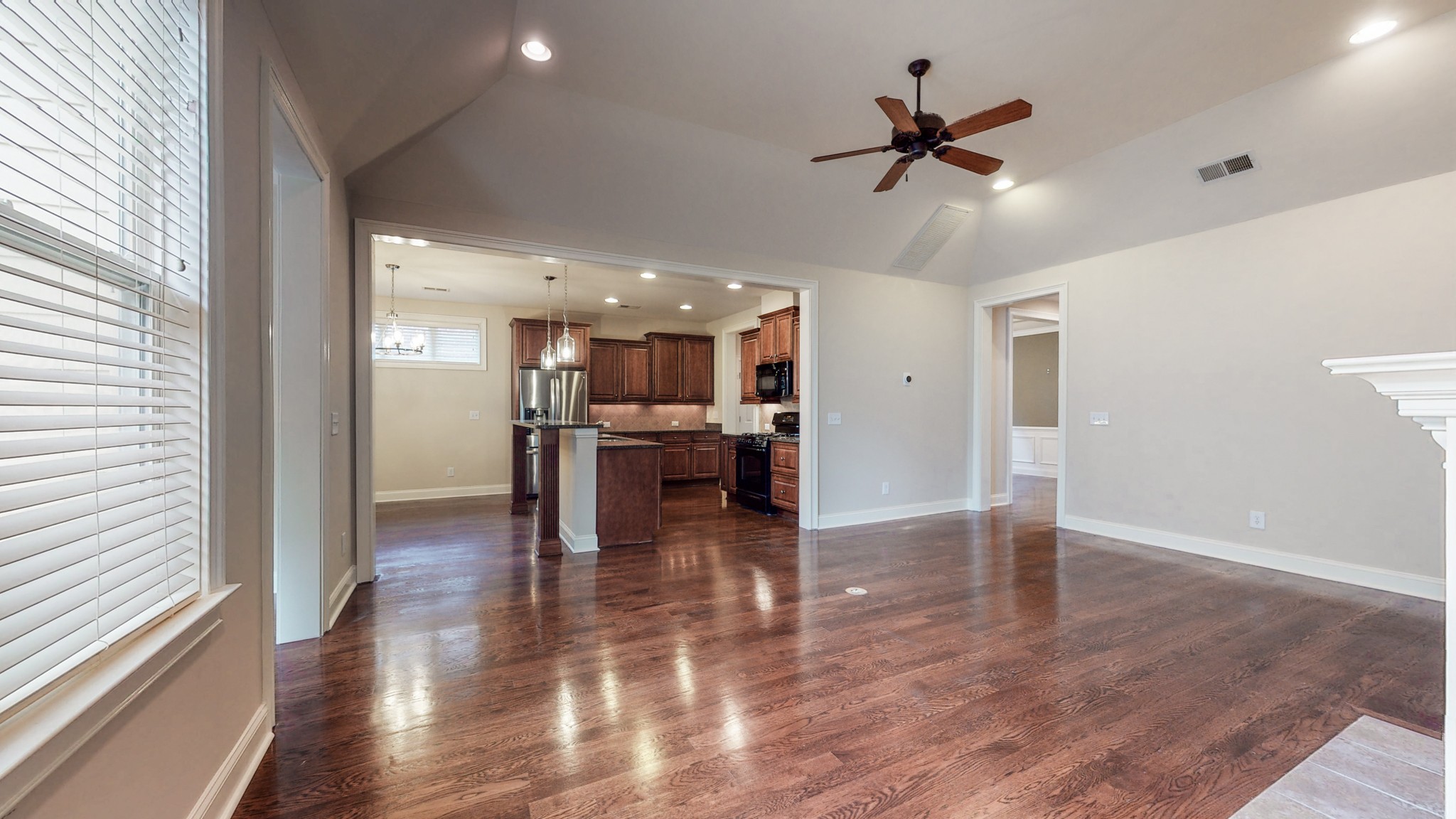 718 Pearre Springs Way Franklin, TN 37064 - Photo 3 of 46 a view of a kitchen with a stove wooden floor and a ceiling fan