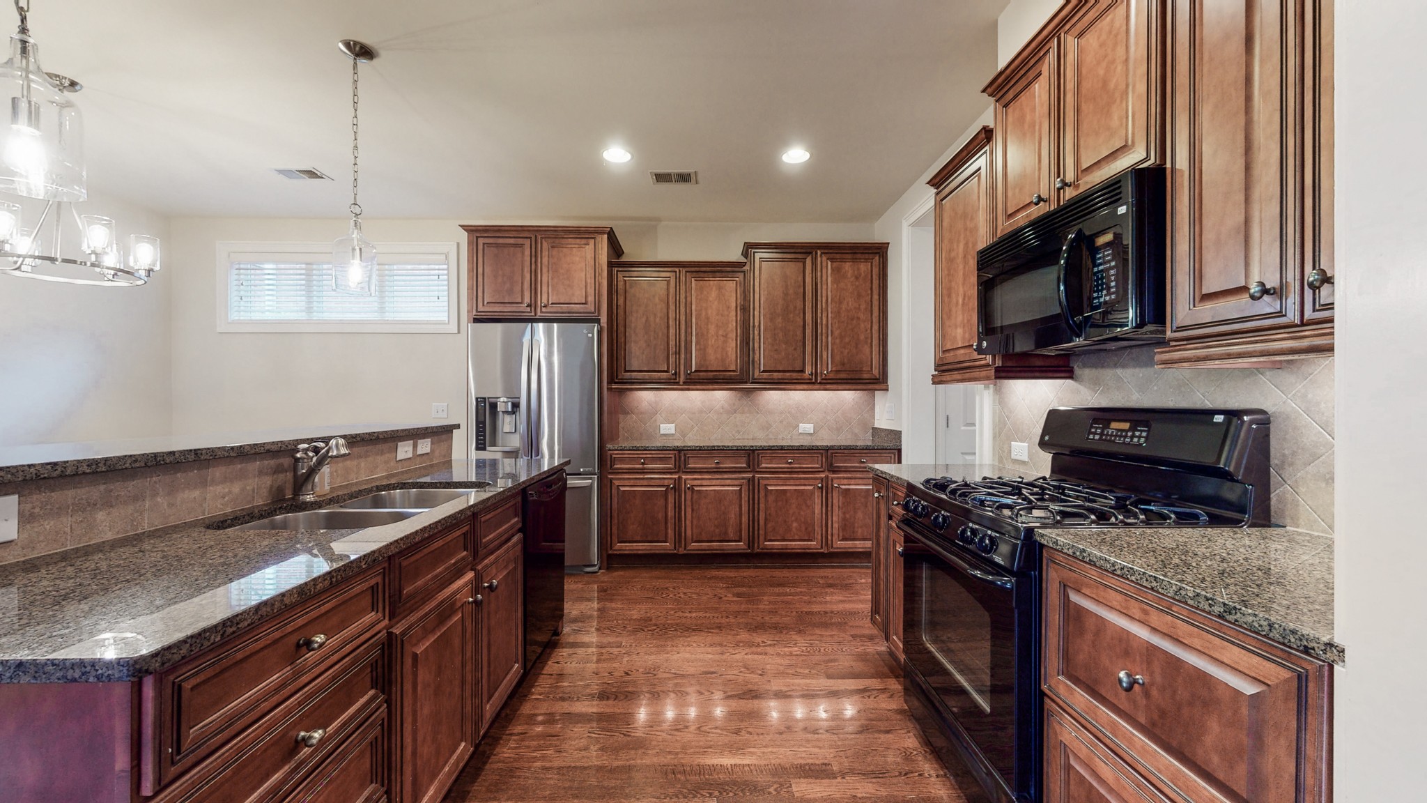 718 Pearre Springs Way Franklin, TN 37064 - Photo 7 of 46 a kitchen with stainless steel appliances granite countertop a stove top oven a sink dishwasher a refrigerator and a microwave