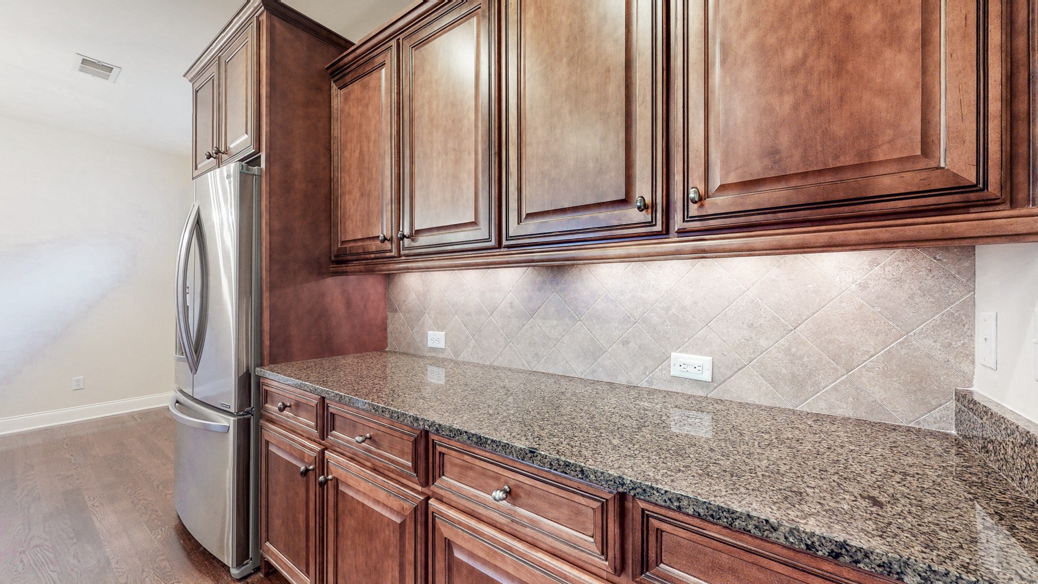 718 Pearre Springs Way Franklin, TN 37064 - Photo 9 of 46 a view of a kitchen with granite countertop cabinets and a wooden floor