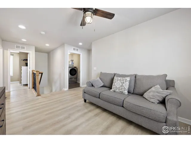 a view of a hallway with wooden floor and stairs