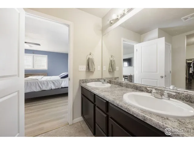 a bathroom with a granite countertop sink two mirror and a shower