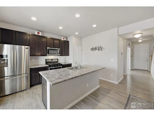 a kitchen with stainless steel appliances granite countertop a sink refrigerator and microwave