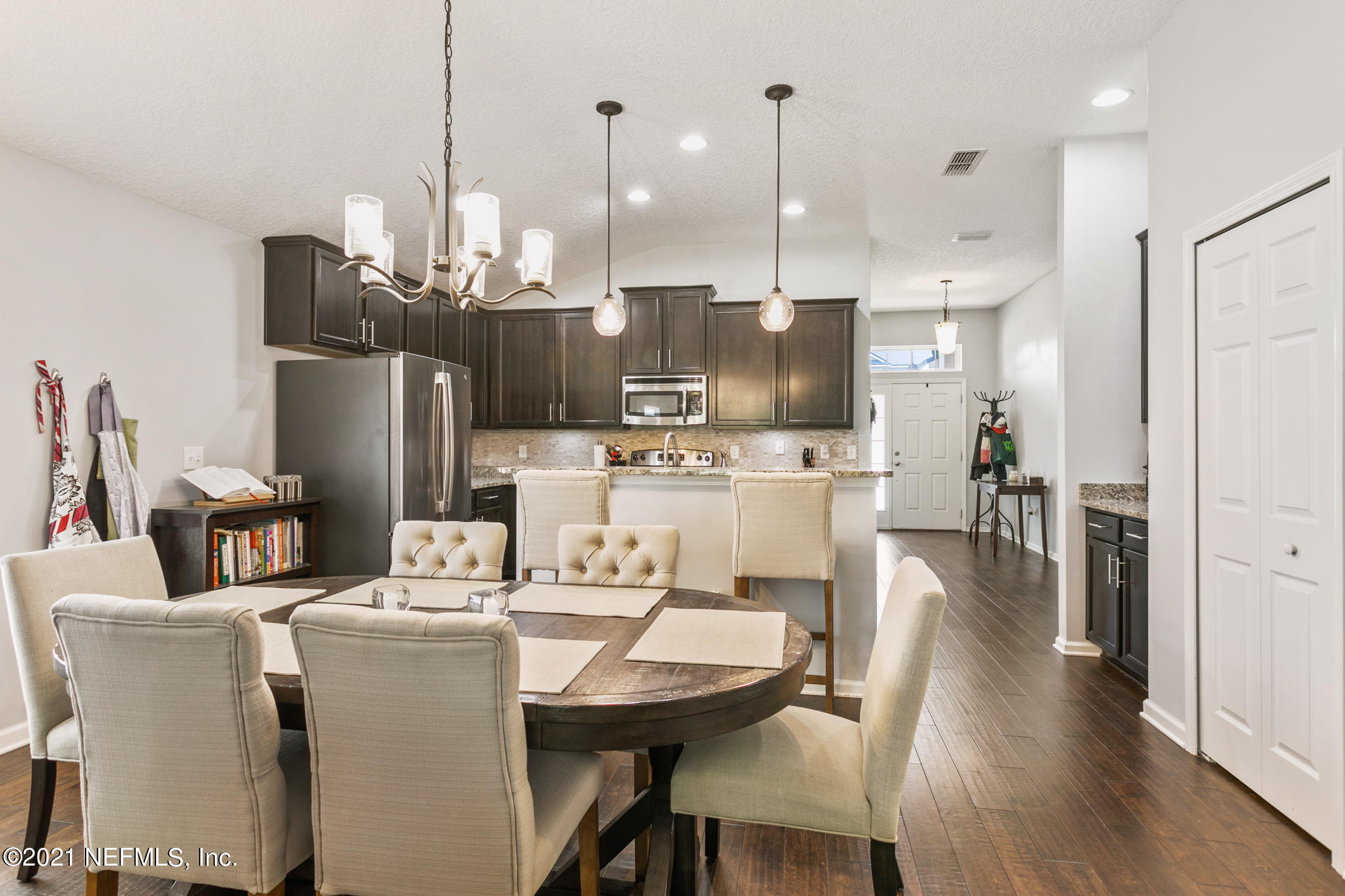 1365 Royal Dornoch Drive Jacksonville, FL 32221 - Photo 14 of 32 a dining room with stainless steel appliances kitchen island a table chairs and a kitchen view