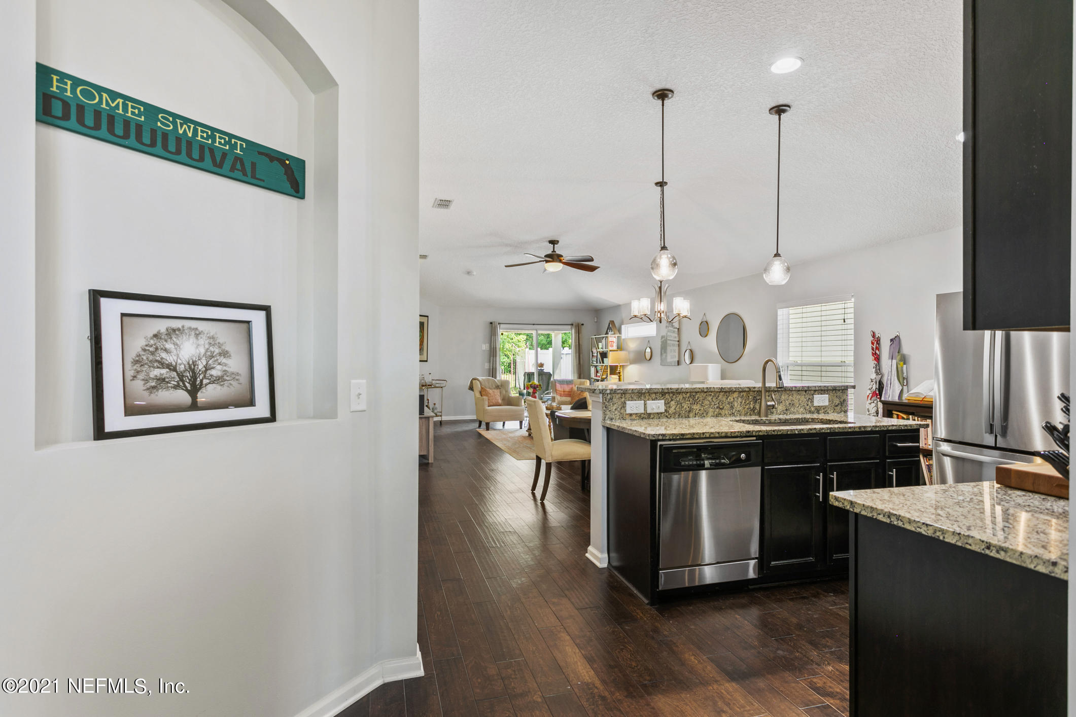 1365 Royal Dornoch Drive Jacksonville, FL 32221 - Photo 8 of 32 a kitchen with stainless steel appliances granite countertop a stove top oven a sink a dining table and chairs with wooden floor