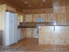212 Campbell Creek Road Maggie Valley, NC 28751 - Photo 4 of 9 a kitchen with granite countertop white cabinets and refrigerator