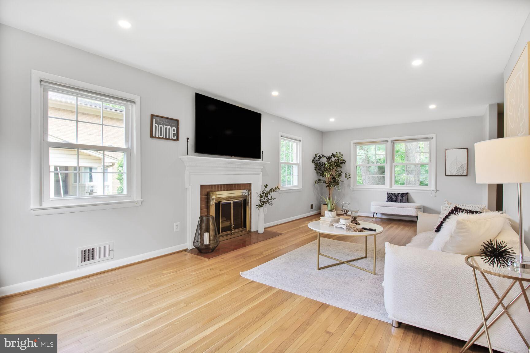 10611 Meadowhill Road Silver Spring, MD 20901 - Photo 2 of 29 a living room with furniture a fireplace and a flat screen tv