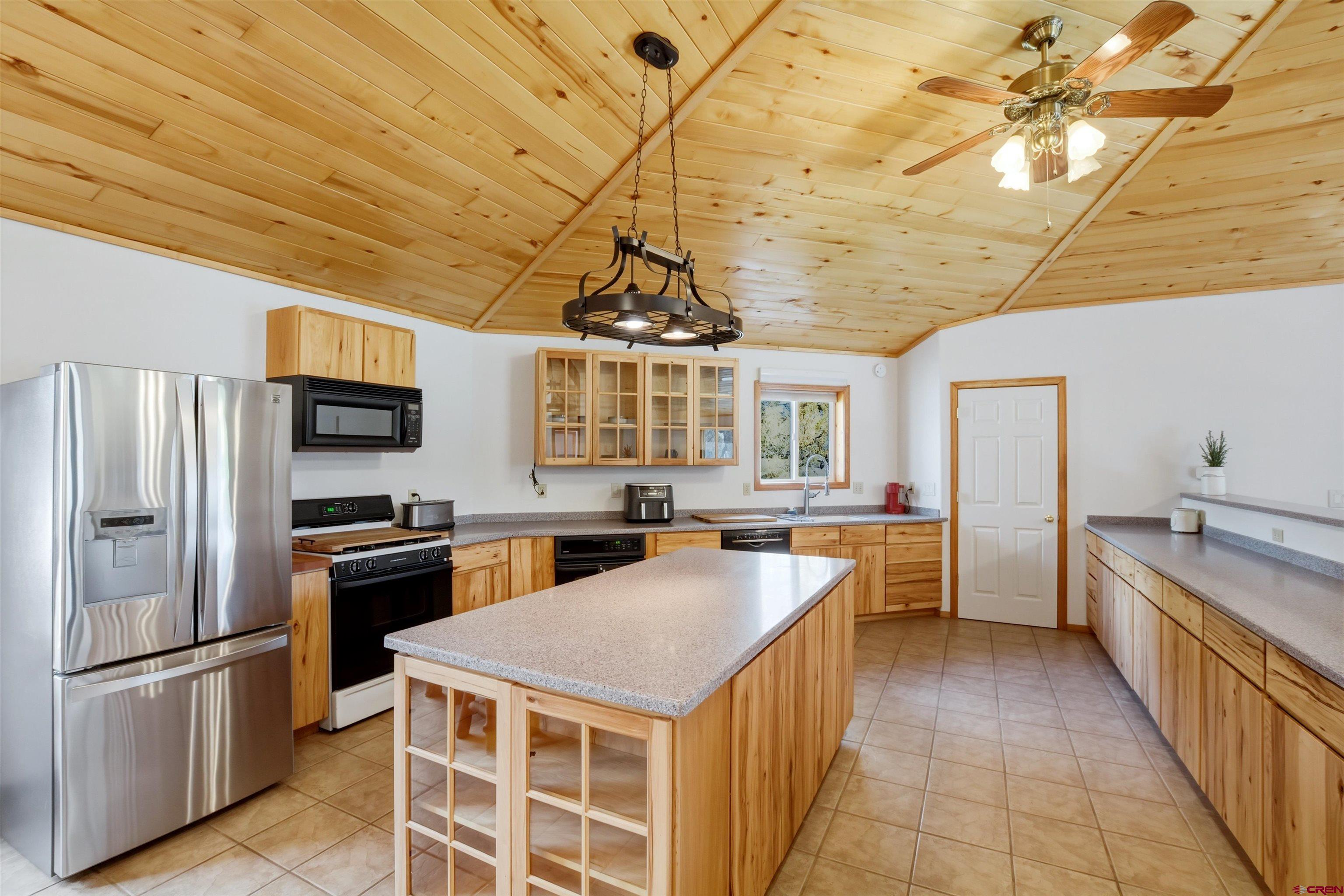 36283 Rd K.3 Mancos, CO 81328 - Photo 16 of 37 a kitchen with stainless steel appliances granite countertop a stove a refrigerator a sink dishwasher and white cabinets with wooden floor