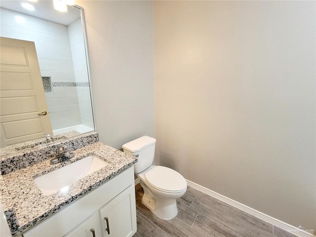 1908 Davenport Street, Unit 1 Weslaco, TX 78596 - Photo 17 of 21 a bathroom with a granite countertop sink and a toilet