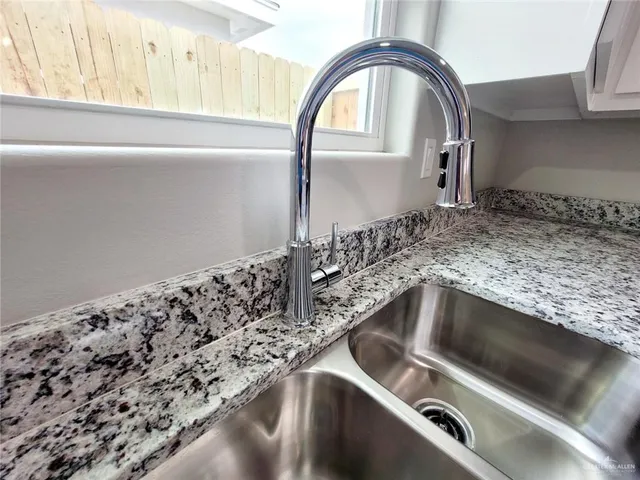 a view of a kitchen with a sink dishwasher a kitchen island hardwood floor and a window