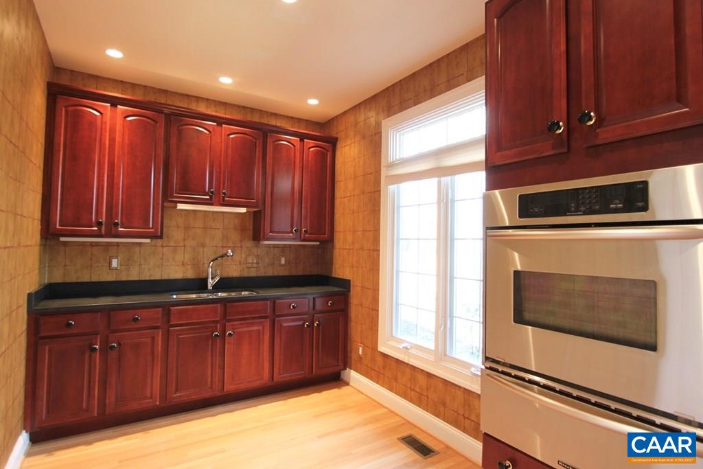 245 Terrell Road West Charlottesville, VA 22901 - Photo 10 of 23 a kitchen with stainless steel appliances granite countertop wooden cabinets a sink and a window