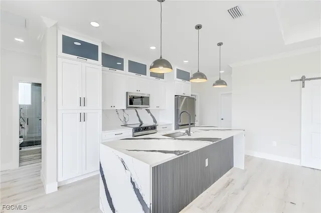 a kitchen with a sink a counter space and a refrigerator