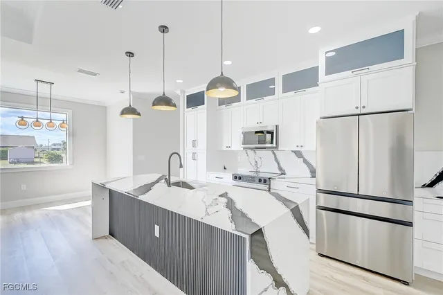a kitchen with a sink a refrigerator a stove and wooden floor