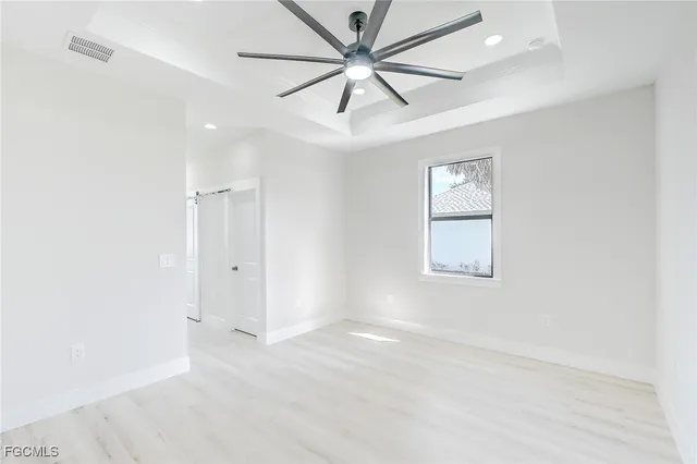 an empty room with fan and windows