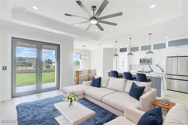 a living room with furniture and a large window with kitchen view