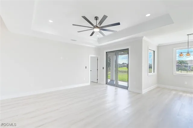 a view of an empty room with window and wooden floor