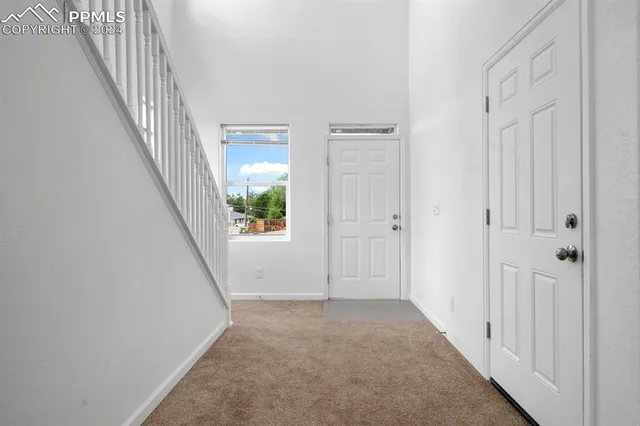 a view of a hallway with wooden floor and entryway