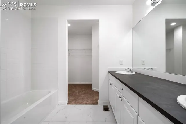 a bathroom with a granite countertop sink a toilet and bathtub