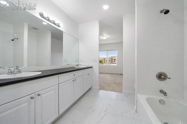 a bathroom with a granite countertop sink mirror and bathtub
