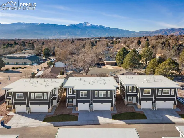 an aerial view of a large building with a mountain