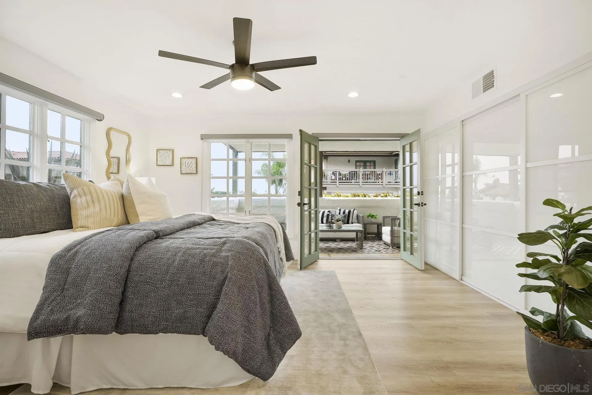 381 Playa Blanca Encinitas, CA 92024 - Photo 15 of 32 a spacious bedroom with a large bed a chandelier and a large window