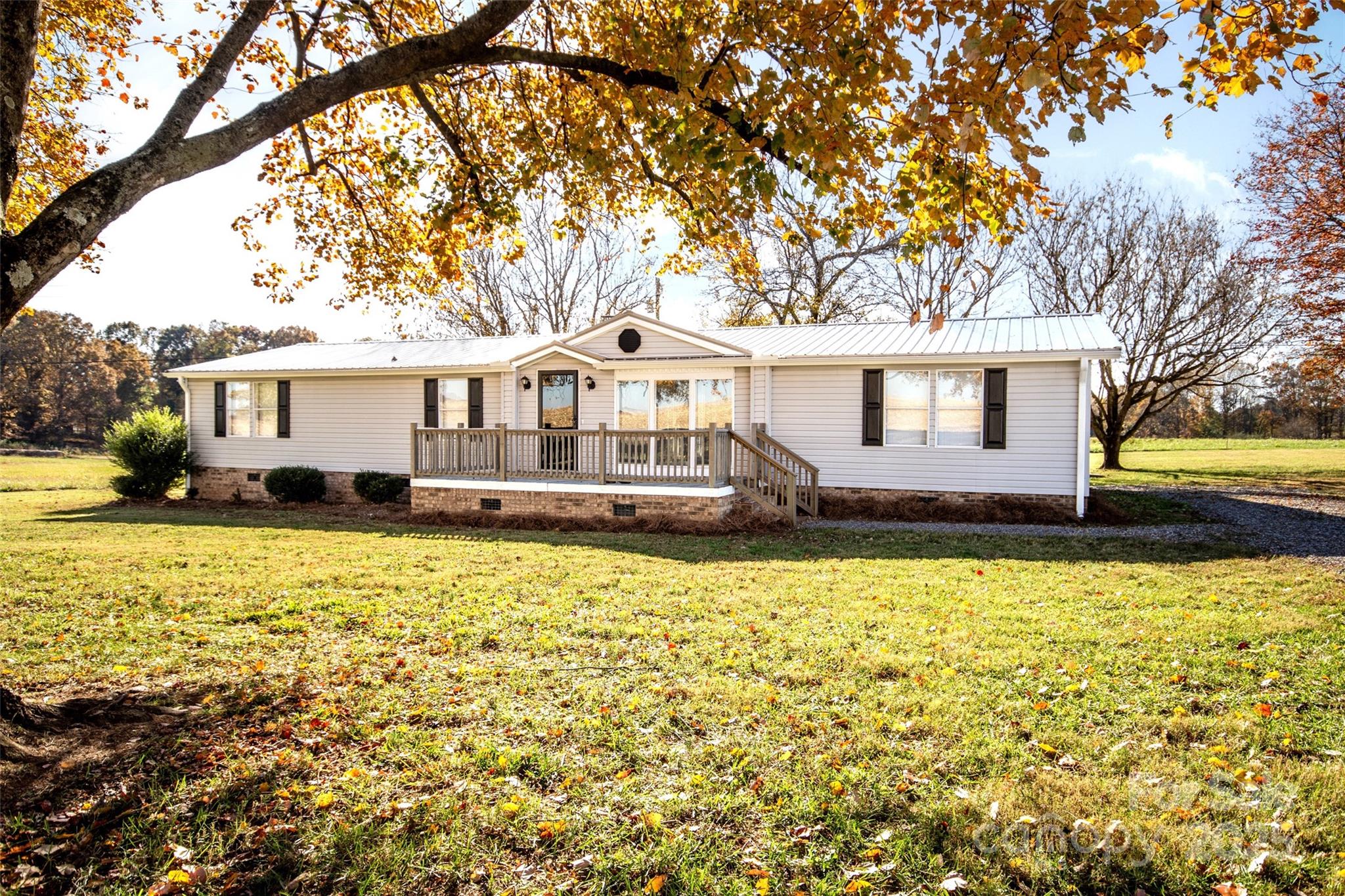 a front view of a house with a large tree