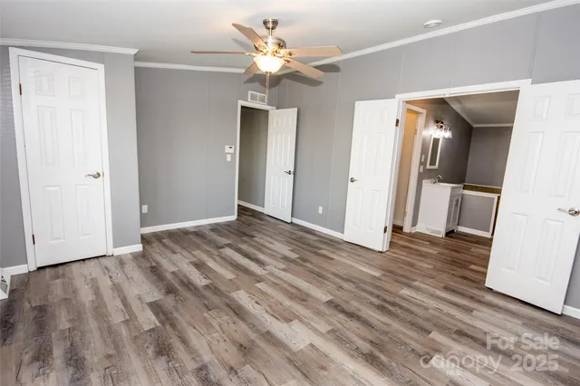 a view of a livingroom with wooden floor and a ceiling fan