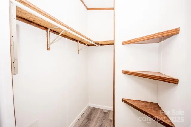 a view of walk in closet with clothes and shoes