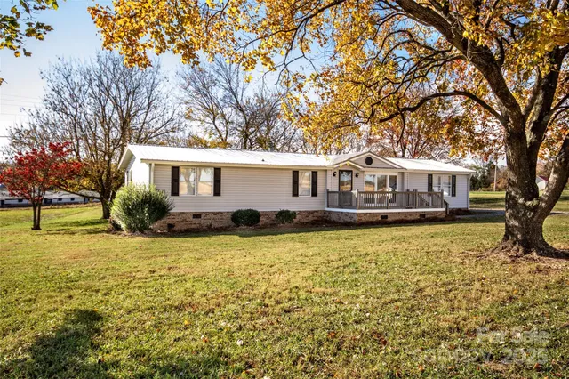 a front view of a house with a large tree