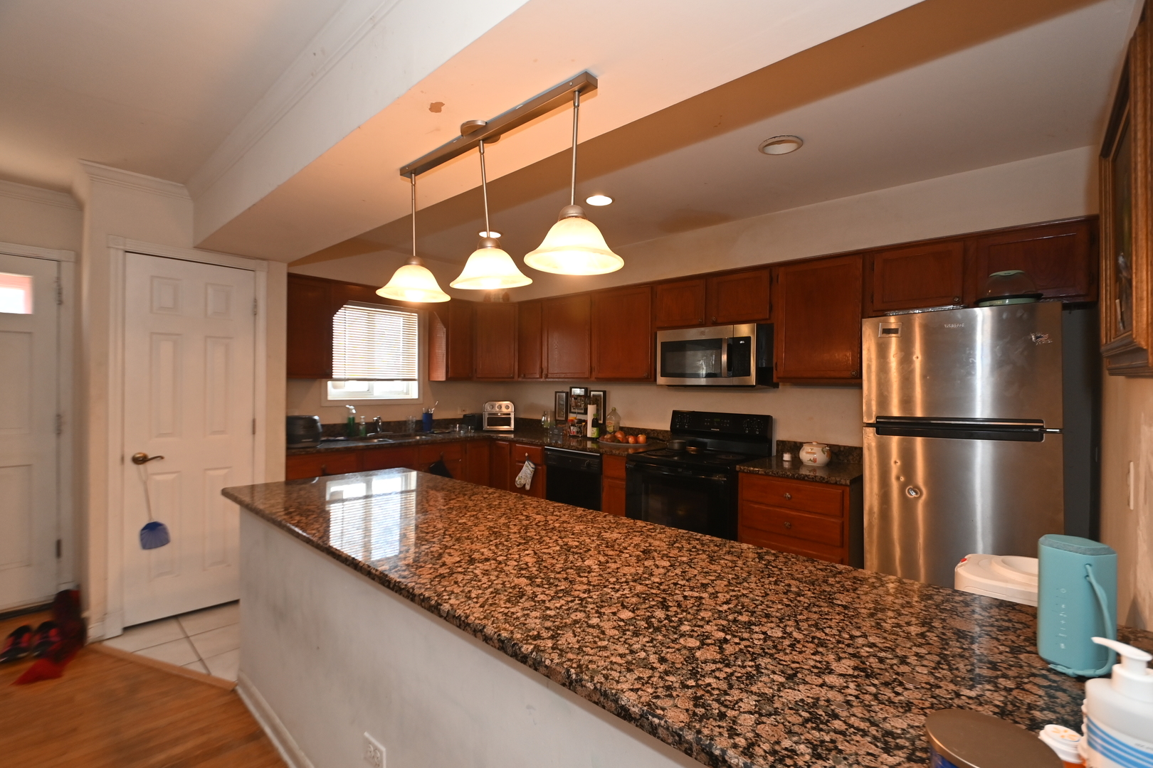 32 1st Street Wheeling, IL 60090 - Photo 5 of 14 a kitchen with stainless steel appliances kitchen island granite countertop a refrigerator a stove and a sink