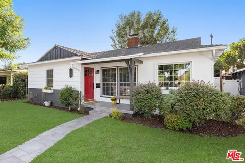 a front view of a house with a garden and plants