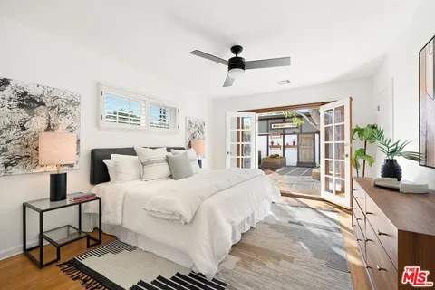 a bedroom with a large bed and a potted plant