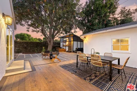 a view of a patio with table and chairs and floor to ceiling window